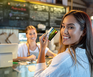 woman at coffee shop holding up card