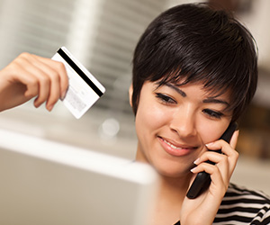 woman with credit card on the phone