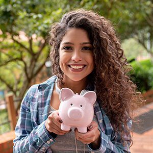 Woman smiling and holding a piggybank 