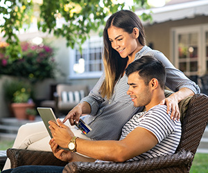 man and woman sitting in chair looking at computer